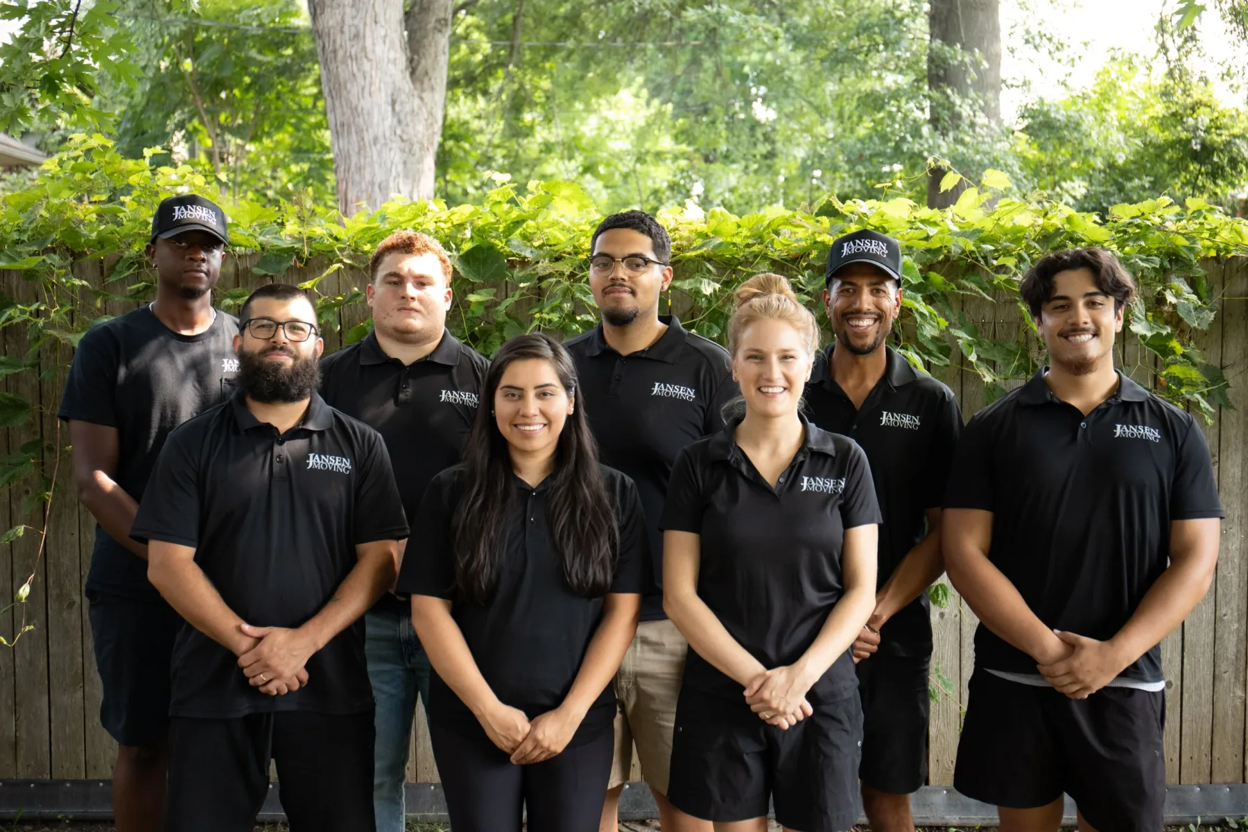 The Jansen Moving team standing together in matching black uniforms